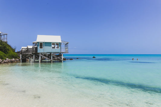 A beautiful beachfront vacation rental with a clear blue sky, and ocean in the background—perfect for an Airbnb getaway in Miami.