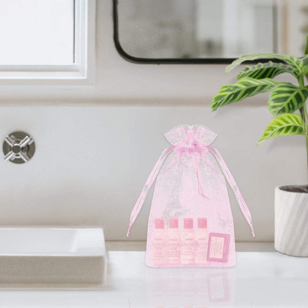 Stylish Aveda Rosemary Mint Toiletry Bags feature premium travel essentials in a sleek pink design for guests.