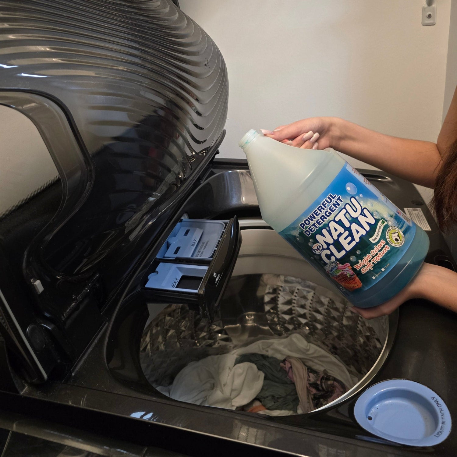 Natu Clean Laundry Detergent – 4 Gallons (Biodegradable) being poured into a washing machine for eco-friendly cleaning.