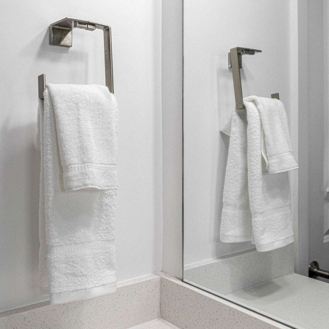Soft, plush Pinnacle Bath towels hang elegantly, showcasing luxury and durability in brilliant white cotton.