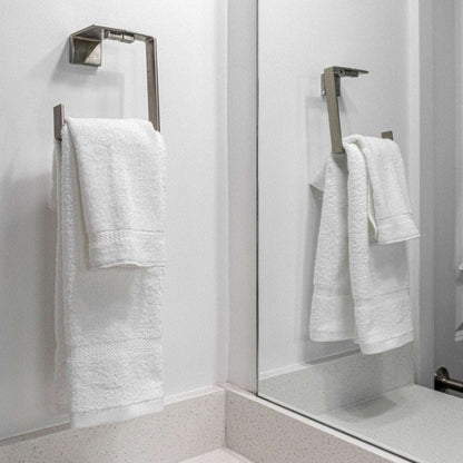 Soft, plush Pinnacle Bath towels hang elegantly, showcasing luxury and durability in brilliant white cotton.