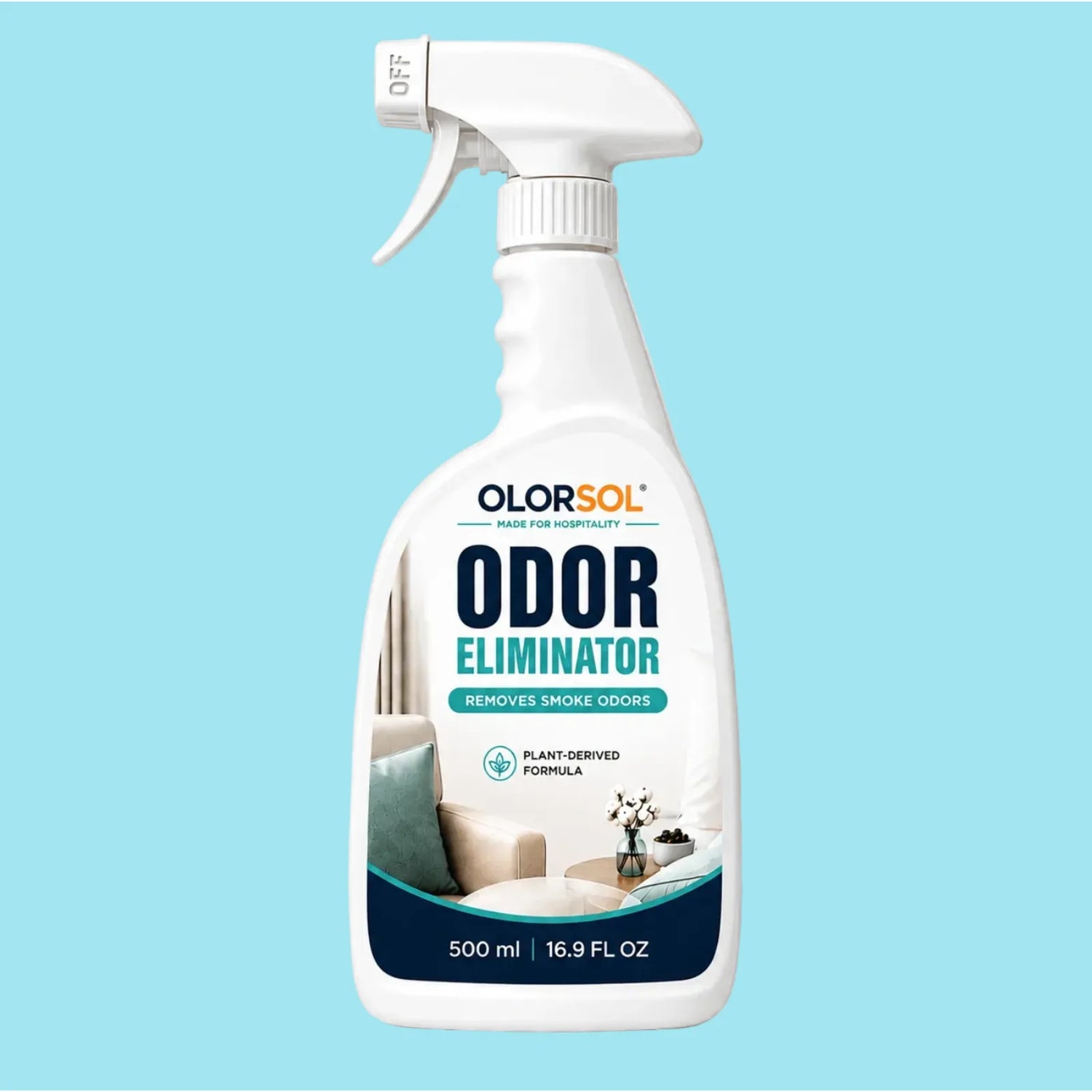 A 500 ml trigger spray bottle of OlorSol Odor Eliminator against a solid light blue background. The bottle is white with a clear spray nozzle and features a label with navy blue and teal text, along with an image of a cozy living room scene.