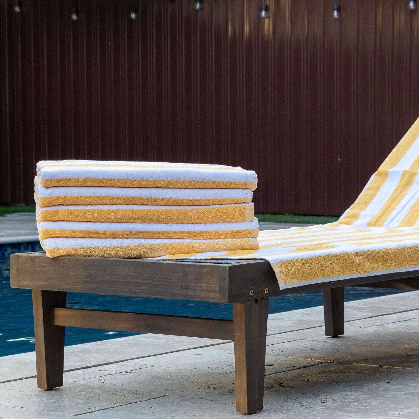 Oxford Premium Cabana Stripe Towels 30"x70" stacked on a poolside lounge chair, perfect for summer relaxation.