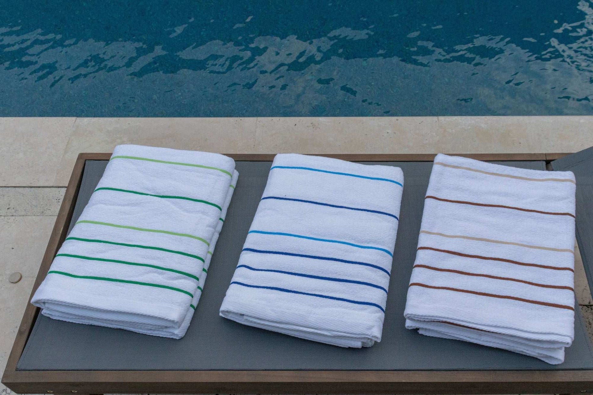 Pinnacle Premium Pool Towels 35" x 70" in vibrant stripes, perfect for luxury hotel poolside relaxation.