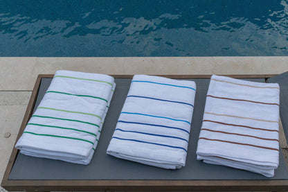 Pinnacle Premium Pool Towels 35" x 70" in vibrant stripes, perfect for luxury hotel poolside relaxation.