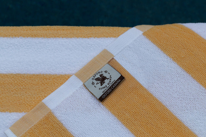 Oxford Premium Cabana Stripe Towels 30"x70" in vibrant yellow and white, perfect for poolside relaxation.